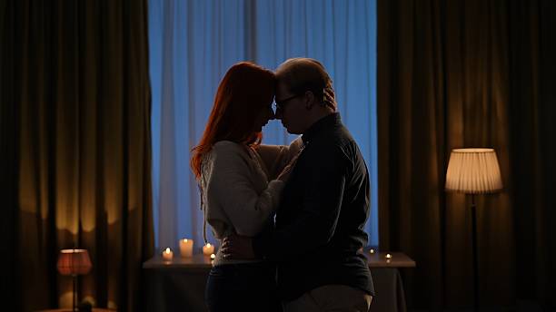 istock Romantic Couple in a Candlelit Room Embracing 2209116420