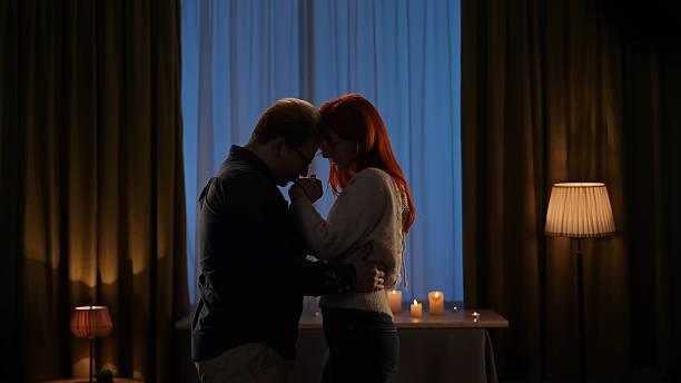 istock Romantic Couple Embracing in a Candlelit Room 2209116854