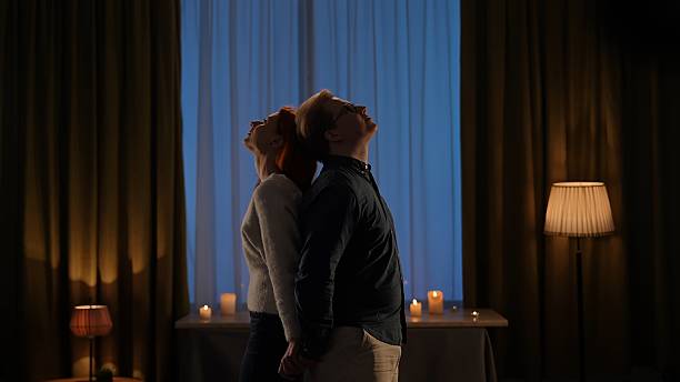 istock Silhouetted Couple Relaxing in Candlelit Evening Scene 2209116973