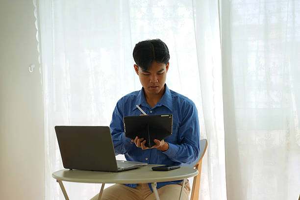 The man is working with laptop at home. Technology and work at home.