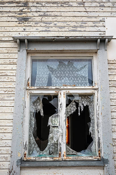 istock Broken windows of a derelict home 2209122408