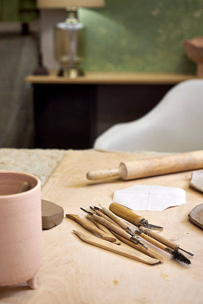 istock workshop table with pottery tools against green wall with lamp, home office concept 2209122706