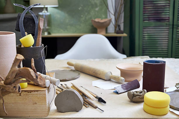 istock workshop table with pottery tools against green wall with lamp, home office concept 2209122799