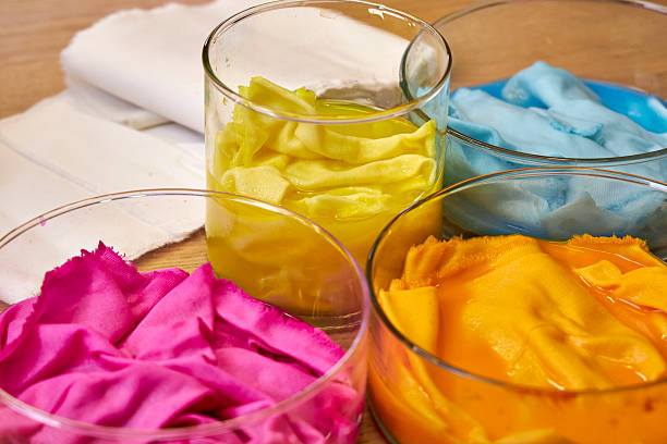 top view of glass flasks with dyed bright fabrics, background for needlework