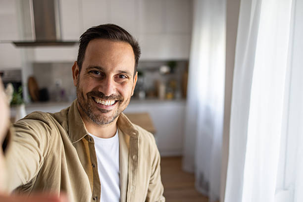 istock Happy man taking a selfie in his modern kitchen 2209124386