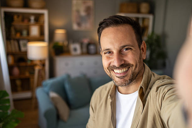 istock Happy man taking a selfie at home, smiling at the camera 2209124393