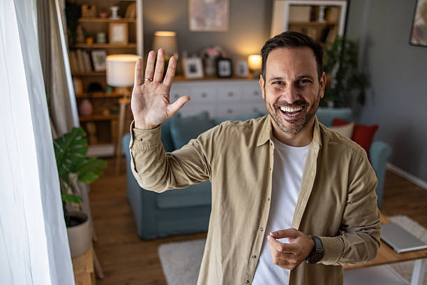 istock Happy man waving hand during video call at home 2209124433