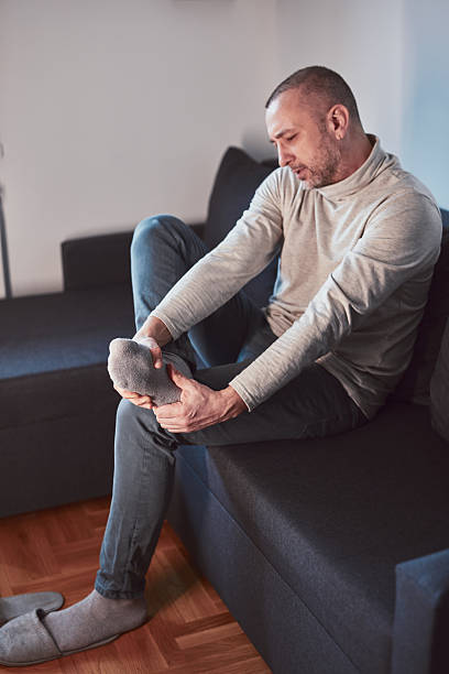 istock Man with ankle and foot pain at home. 2209124947