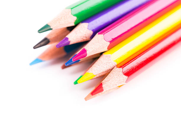 A collection of colored pencils in various shades including green, purple, yellow, and red are neatly arranged. The vibrant colors create an inviting setup for artistic activities.