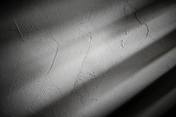 istock Light and shadow play on a textured wall during the quiet hours of early morning, creating a subtle dance of contrasts 2209126158
