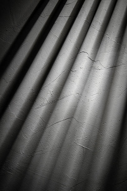 istock Light streams through shutters illuminating a textured wall creating a play of shadows and light in a dimly lit space during early morning hours 2209126173