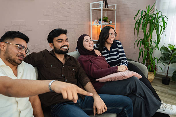 istock Four friends watching tv and having fun at home 2209126906