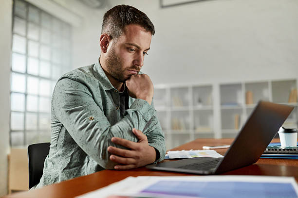 istock Thoughtful creative man working on laptop in the office. 2209128393