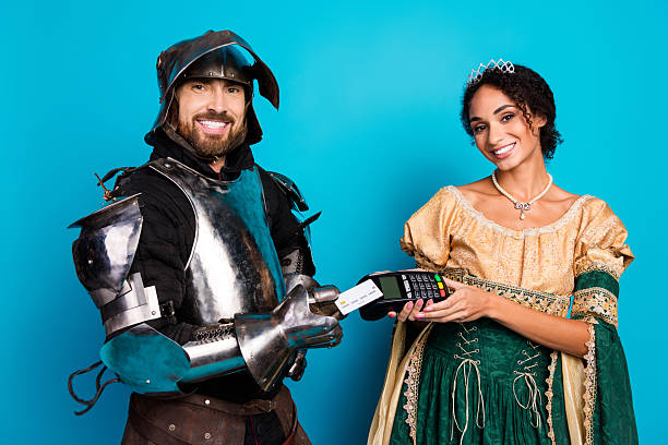 istock Royal Couple in Medieval Costumes Using Modern Payment Device Against Vibrant Background 2209128575