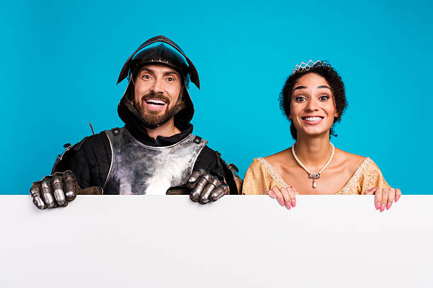 istock Young couple in medieval costumes presenting happy expressions against a bright backdrop 2209128661