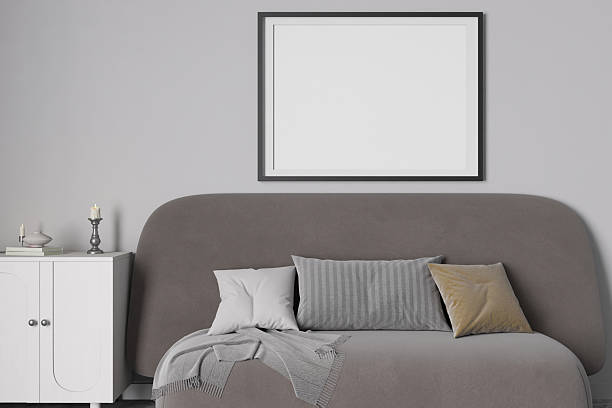 istock This interior setting showcases a stylish gray sofa adorned with decorative cushions, creating a serene atmosphere. A blank picture frame hangs above, offering an ideal space for personalization. 3D. 2209131127