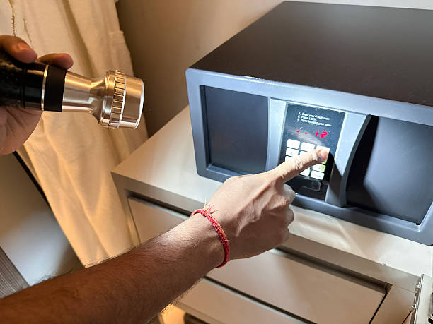 istock Image of thief using flashlight and laptop near secured vault in hotel suite / hidden assets at risk, digital break-in, interior crime scene 2209131236