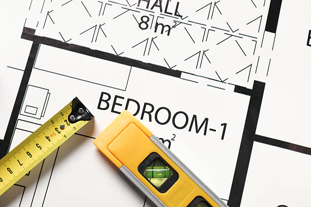 istock Measuring tape and building level on different architectural drawings, top view 2209133561