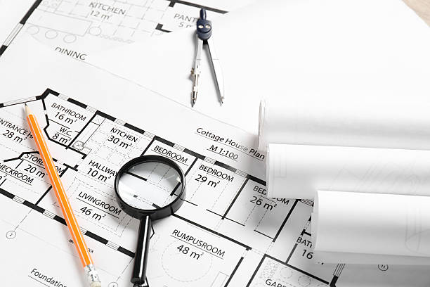 istock Dividers, pencil and magnifying glass on different architectural drawings 2209133612