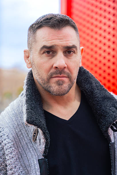 istock Caucasian man looking serious while standing near red structure in urban setting 2209133886