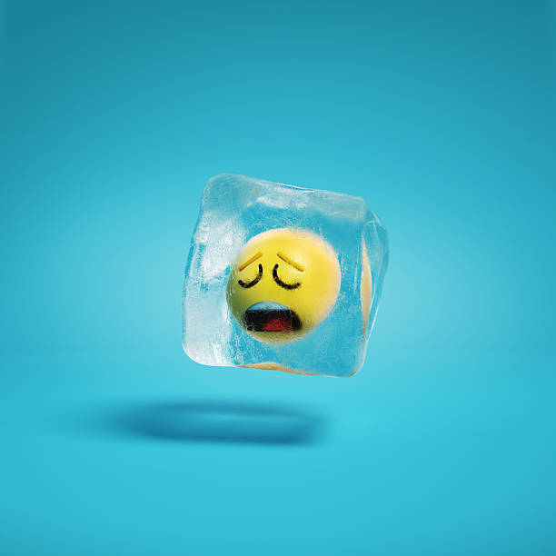 istock Weary face emoji with closed eyes, furrowed brows and open frown inside ice cube. 2209136510