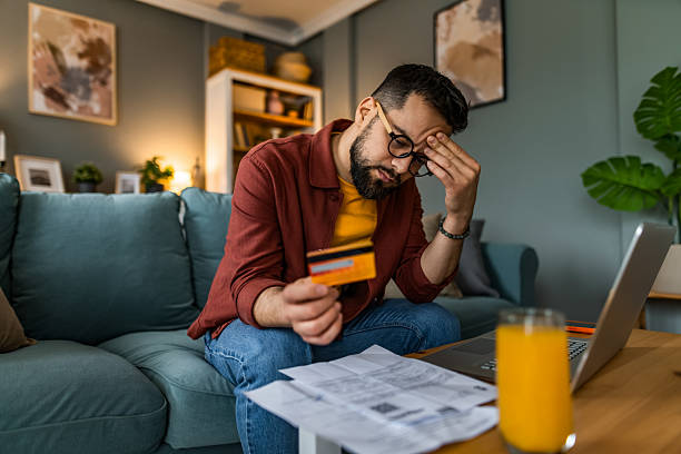 istock Displeased man having problems with paying financial bills at home 2209136741
