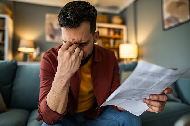 家で金銭的な請求書を支払うのに問題を抱えている心配な男。 - 驚く 男性 ストックフォトと画像