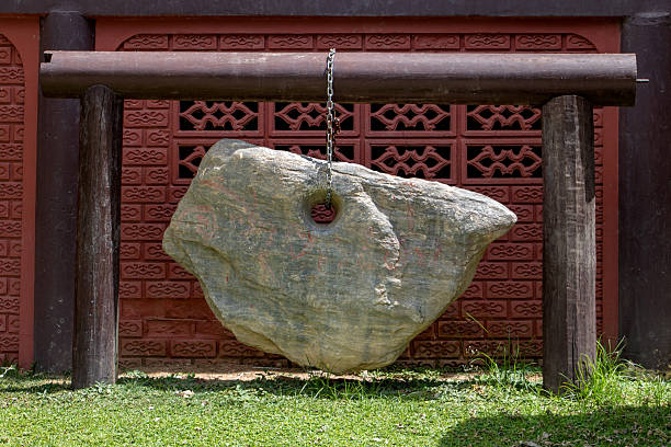 Decorative boulder hanging on a chain in Buddhist temple, Thailand. Lucky rock.