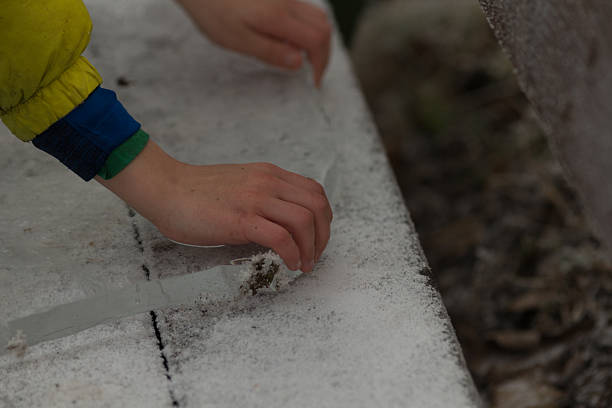 istock Hand Pulling a Piece of Ice from River or Lake 2209140909