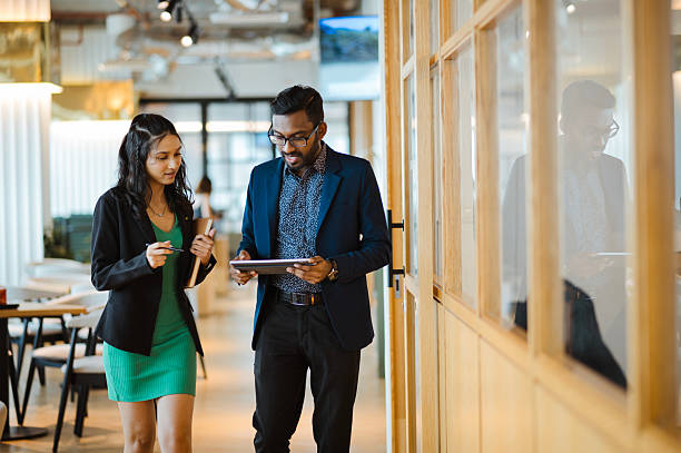 istock Business Colleagues Walking and Talking in Office Hallway 2209141093