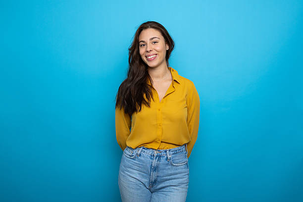 istock Confident latin woman posing with relaxed hands behind back, beaming smile against bright blue background 2209142839
