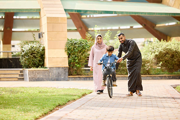 istock Boy learning bicycle with assistance of father 2209144193