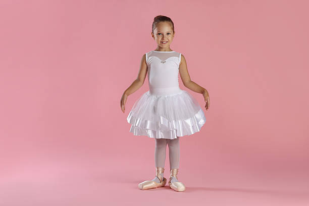istock Little ballerina practicing dance moves on pink background 2209144352