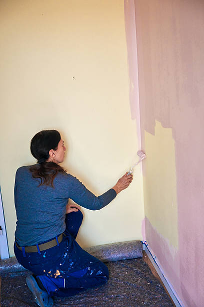 istock Painting a Wall by Using Paint Roller to Cover the Surface 2209144448