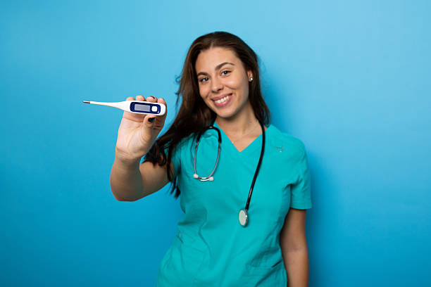 Medical professional checking patient temperature, wearing white coat