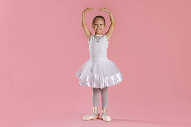 istock Little ballerina practicing dance moves on pink background 2209148201