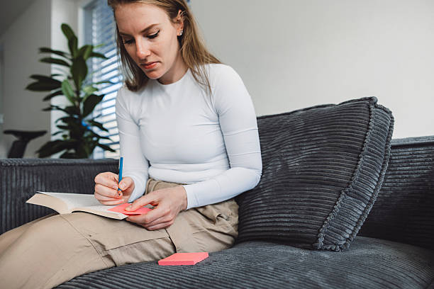 istock Young Woman study at home using sticky note to bookmark. 2209148325