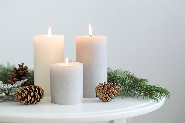 istock Burning candles and fir branches on coffee table near light wall, space for text. Christmas atmosphere 2209149250