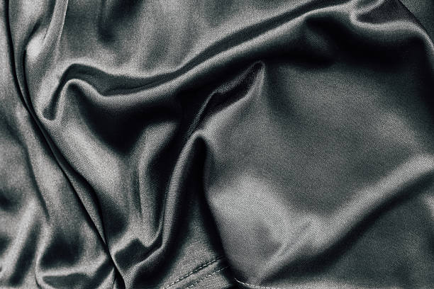 istock Silky black fabric draped elegantly with varied textures and deep shadows in natural light 2209149934