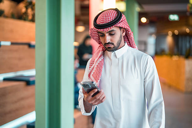 istock Young Middle Eastern Businessman in Traditional Attire Using Smartphone in Modern Office Setting 2209151812