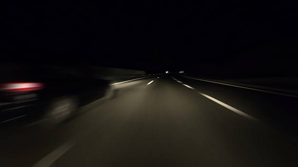 istock Driving on modern highway with bright lights on road at night 2209152444