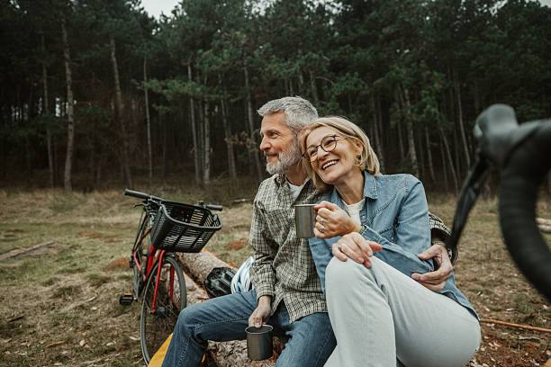 istock Mature couple embracing while sitting on tree log 2209156577