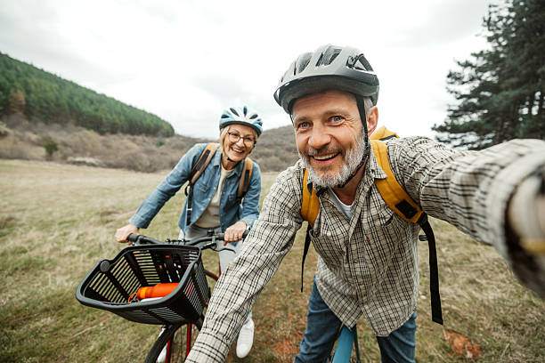 Cheerful mature couple taking a selfie while resting from their bicycle ride