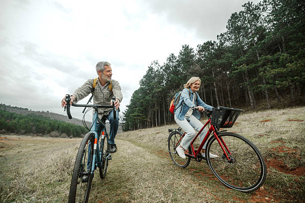 istock Mature couple cycling through peaceful forest trail 2209156925