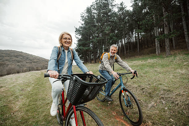 istock Casually clothed mature couple riding bicycles in forest 2209157277