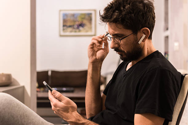 istock Young middle-aged man using smartphone and Bluetooth headphones 2209157527