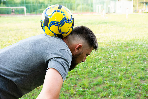 istock Man balancing soccer ball on his neck, outdoors.  Focused expression, athletic build. 2209162613