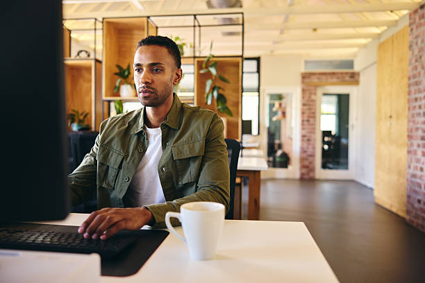 istock Businessman sitting at desk working on computer 2209164427