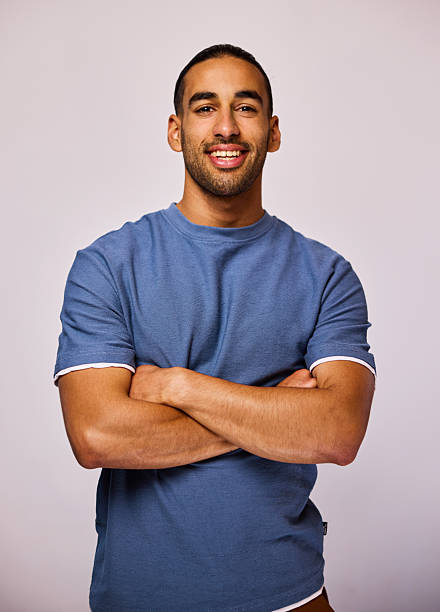 Studio portrait of cheerful businessman wearing blue t-shirt looking at camera stock photo