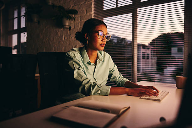 istock Businesswoman wearing glasses working late on computer 2209164602